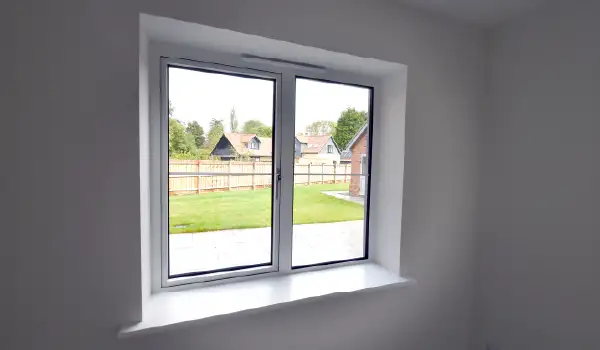 Internal view of a white Cortizo aluminium window looking out into the garden of a new-build property in Stonham Aspal, Suffolk