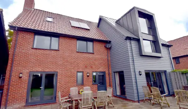 Rear view of a property in Ufford, Suffolk showcasing the installation of Schueco aluminium windows, doors and bi-folding door by Site Fix Fenestration Ltd.